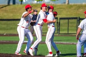 Jacoby Hogencamp (center) and Catholic Memorial celebrate the Knights' semifinal win over Cambridge. (Patrick Donnelly/NEBJ)
